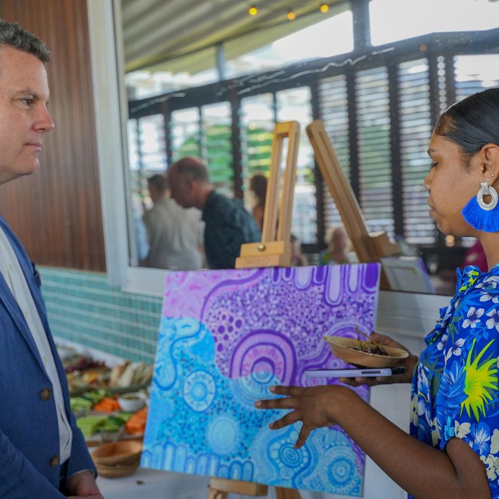 Velda explaining Trent her artwork